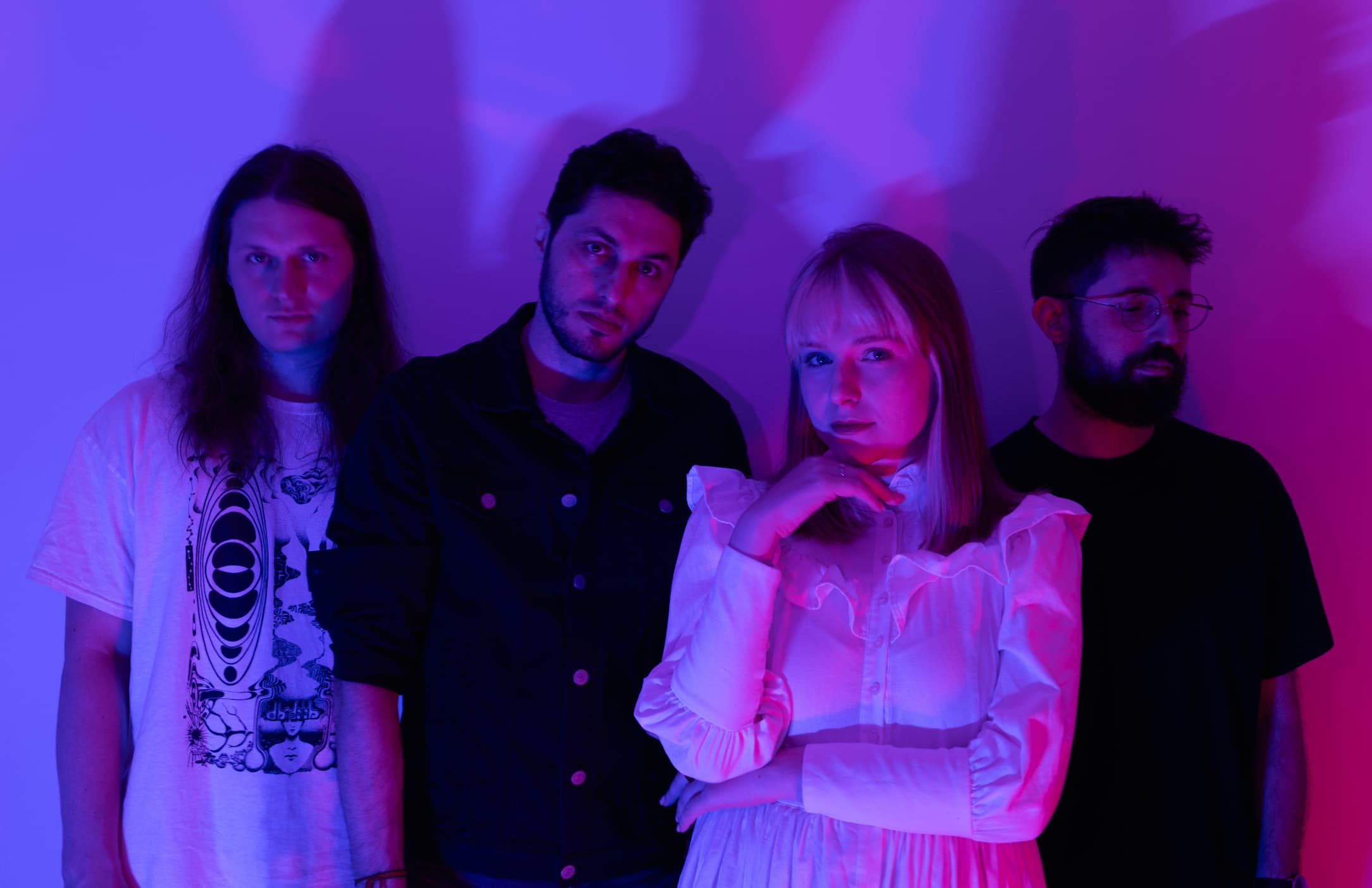 Band members posing under a violet light