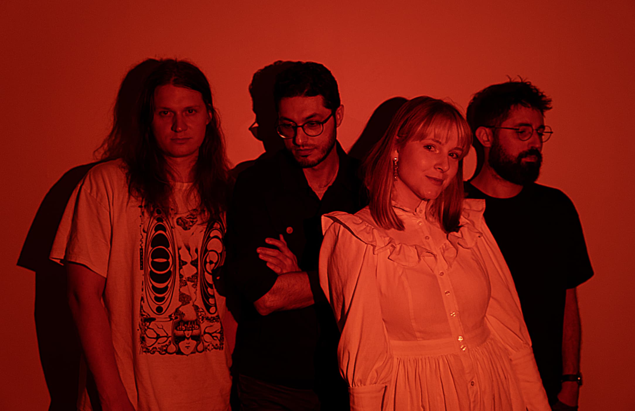 Band members posing under a red light